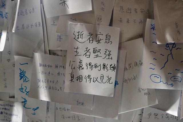 Messages left by mourners are seen during a vigil held outside the Wang Fuk Court apartment blocks in the aftermath of the deadly November 26 fire in Hong Kong's Tai Po district on December 3, 2025. (Photo by Tommy WANG / AFP)
