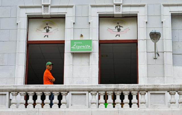 A man stands on a balcony during a power outage in Havana, on December 3, 2025. Millions of people were left without electricity on December 3 in western Cuba, including Havana, due to damage to the power grid in that region of the island, which has been suffering recurrent blackouts for two years. (Photo by ADALBERTO ROQUE / AFP)