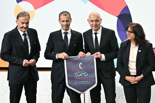 (From L) UEFA Vice-President Hans-Joachim Watzke, UEFA President Aleksander Ceferin, German Football Association (DFB) president Bernd Neuendorf and UEFA Managing Director of Communications Pedro Pinto (R) pose after Germany was elected to host the UEFA Women's EURO 2029 fooball tournament during an announcement ceremony at the UEFA headquarters, the House of European Football, in Nyon on December 3, 2025.  (Photo by Fabrice COFFRINI / AFP)