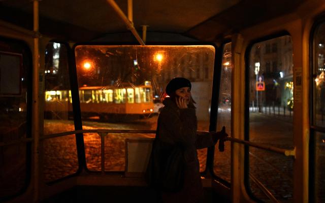A woman speaks on a mobile phone as she rides a tram in Lviv on December 3, 2025, amid the Russian invasion of Ukraine. (Photo by Sergei GAPON / AFP)