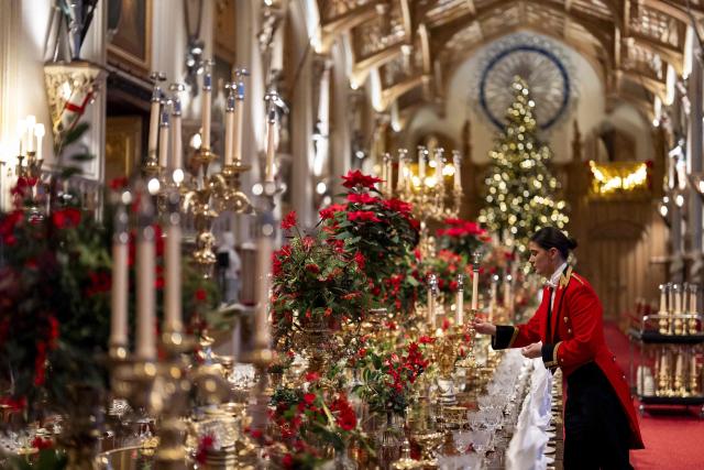 A member of Royal Household staff prepares the table ahead of a  State Banquet for the German President and his wife, at Windsor Castle, in Windsor, on December 3, 2025, the first day of a three day state visit by the German President. President Frank-Walter Steinmeier received a ceremonial welcome to Britain Wednesday as his state visit got into full swing -- the first by Germany's official head of state in 27 years. (Photo by Aaron Chown / POOL / AFP)