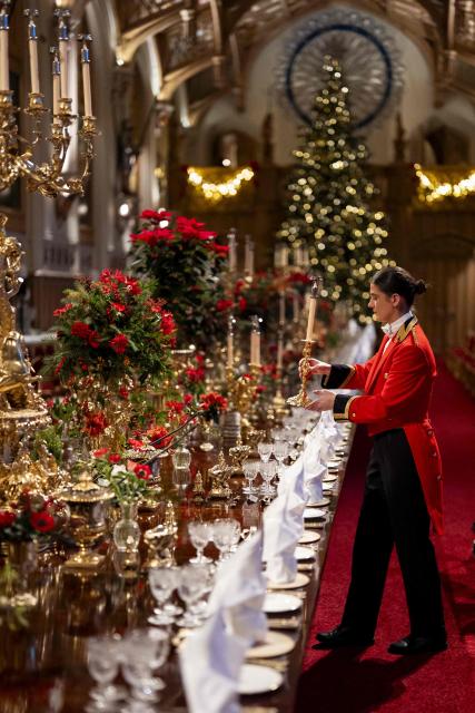 A member of Royal Household staff prepares the table ahead of a  State Banquet for the German President and his wife, at Windsor Castle, in Windsor, on December 3, 2025, the first day of a three day state visit by the German President. President Frank-Walter Steinmeier received a ceremonial welcome to Britain Wednesday as his state visit got into full swing -- the first by Germany's official head of state in 27 years. (Photo by Aaron Chown / POOL / AFP)