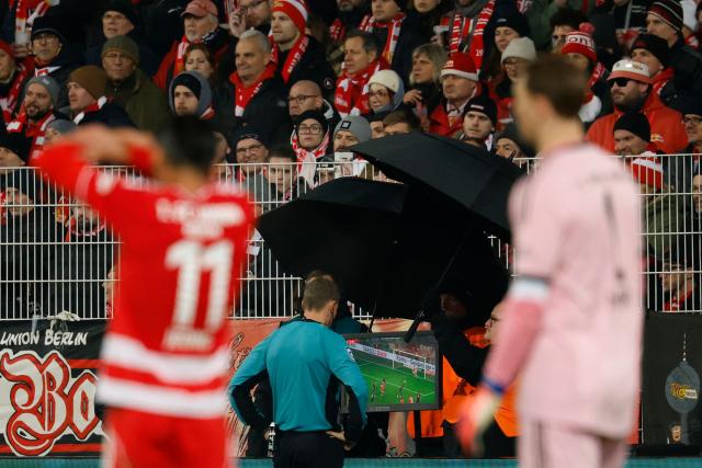 A referee checks the VAR (video assisted referee) monitor during the German Cup (DFB-Pokal) round of 16 football match between 1 FC Union Berlin and FC Bayern Munich in Berlin on December 3, 2025. (Photo by Odd ANDERSEN / AFP) / DFB REGULATIONS PROHIBIT ANY USE OF PHOTOGRAPHS AS IMAGE SEQUENCES AND QUASI-VIDEO.