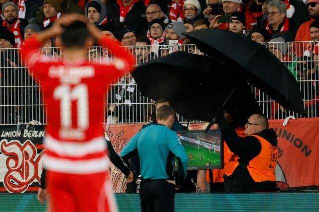 Union Berlin's South Korean midfielder #11 Jeong Woo-yeong reacts as a referee checks the VAR (video assisted referee) during the German Cup (DFB-Pokal) round of 16 football match between 1 FC Union Berlin and FC Bayern Munich in Berlin on December 3, 2025. (Photo by Odd ANDERSEN / AFP) / DFB REGULATIONS PROHIBIT ANY USE OF PHOTOGRAPHS AS IMAGE SEQUENCES AND QUASI-VIDEO.