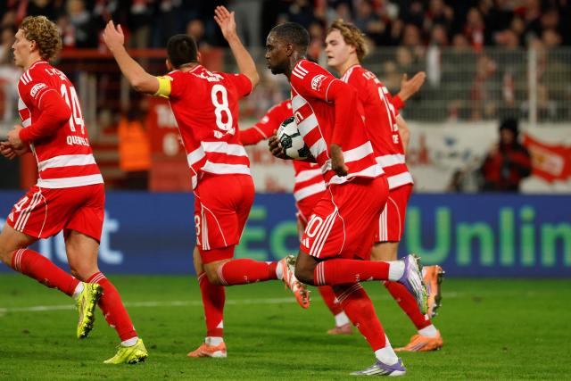 Union Berlin's Austrian defender #14 Leopold Querfeld (L) celebrates after scoring a goal with Union Berlin's German forward #10 Ilyas Ansah and teammates during the German Cup (DFB-Pokal) round of 16 football match between 1 FC Union Berlin and FC Bayern Munich in Berlin on December 3, 2025. (Photo by Odd ANDERSEN / AFP) / DFB REGULATIONS PROHIBIT ANY USE OF PHOTOGRAPHS AS IMAGE SEQUENCES AND QUASI-VIDEO.
