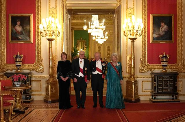 Britain's King Charles III and his wife Britain's Queen Camilla pose with Germany's President Frank-Walter Steinmeier and his wife Elke Buedenbender pose as they arrive to attend a State Banquet at Windsor Castle in Windsor, on December 3, 2025, the first day of a three day state visit by the German President. President Frank-Walter Steinmeier received a ceremonial welcome to Britain Wednesday as his state visit got into full swing -- the first by Germany's official head of state in 27 years. (Photo by CARLOS JASSO / POOL / AFP)