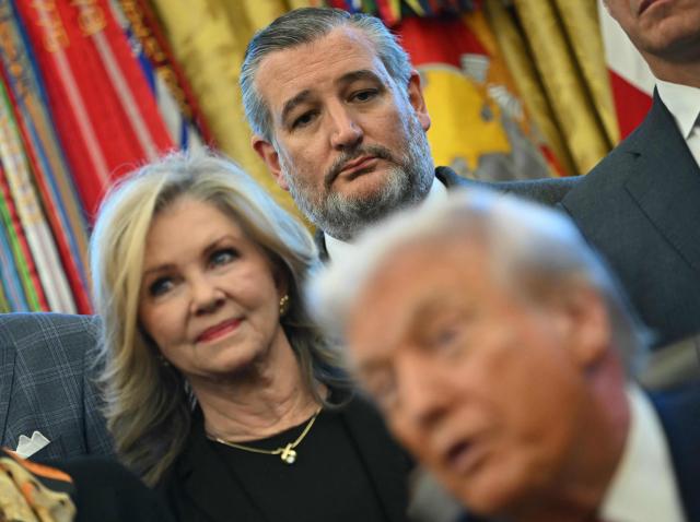 US Senators Marsha Blackburn (L), Republican of Tennessee, and Ted Cruz (C), Republican of Texas, listen as President Donald Trump makes an announcement from the Oval Office of the White House in Washington, DC on December 3, 2025. President Trump announced weaker fuel efficiency standards for the country, as part of his agenda to lower the price of gasoline-powered cars. (Photo by ANDREW CABALLERO-REYNOLDS / AFP)