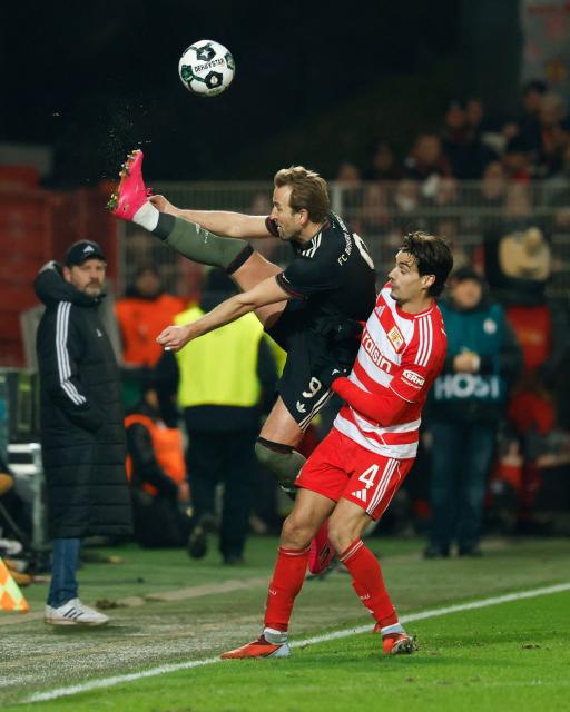 Bayern Munich's English forward #09 Harry Kane (L) and Union Berlin's Portuguese defender #04 Diogo Leite vie for the ball during the German Cup (DFB-Pokal) round of 16 football match between 1 FC Union Berlin and FC Bayern Munich in Berlin on December 3, 2025. (Photo by Odd ANDERSEN / AFP) / DFB REGULATIONS PROHIBIT ANY USE OF PHOTOGRAPHS AS IMAGE SEQUENCES AND QUASI-VIDEO.