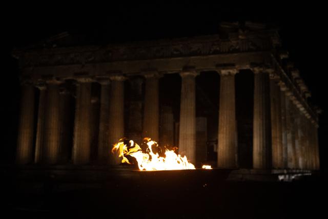 This photograph shows the cauldron with the Olympic flame in front of the ancient temple of the Parthenon atop the Acropolis hill during the Olympic torch relay in Athens on December 3, 2025. (Photo by Angelos TZORTZINIS / AFP)