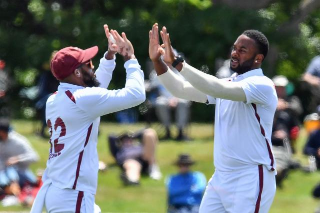 West Indies' Ojay Shields (R) and John Campbell celebrate the dismissal of New Zealand's Devon Conway during day three of the first Test cricket match between New Zealand and West Indies at Hagley Oval in Christchurch on December 4, 2025. (Photo by Sanka Vidanagama / AFP)