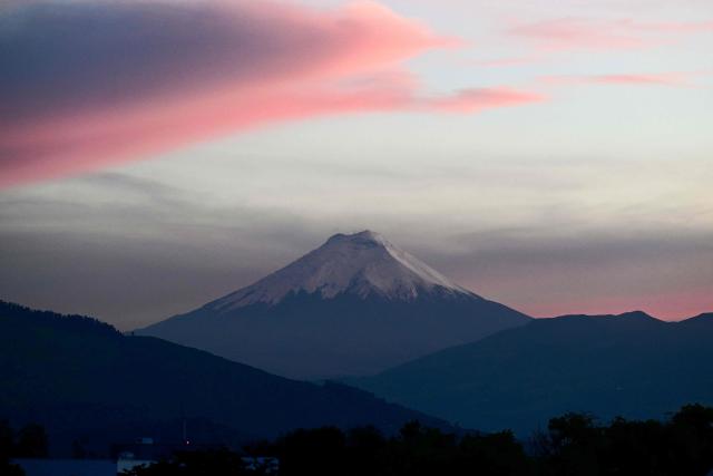 A view of the Cotopaxi volcano during sunset taken from Quito on December 3, 2025. (Photo by Rodrigo BUENDIA / AFP)