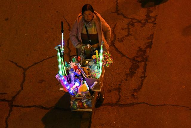 A woman sells Christmas toys in the annual parade marking the start of the festive season in La Paz, December 3, 2025. (Photo by Aizar RALDES / AFP)