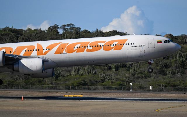 A Conviasa Airlines plane lands at Simon Bolivar International Airport in Maiquetia, Venezuela, on December 3, 2025. Venezuela announced on December 2, 2025, that it had reauthorized flights carrying migrants deported by the US, days after suspending them due to President Donald Trump's demand that Venezuelan airspace be considered "closed." (Photo by Juan BARRETO / AFP)