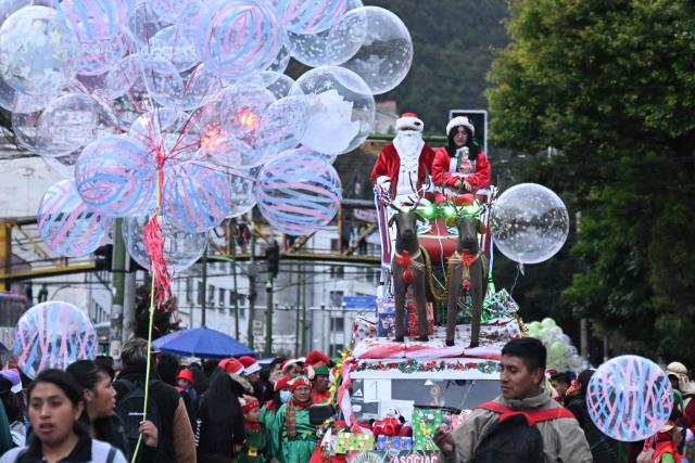 A man dressed as Santa Claus waves from a sleigh during the annual Christmas parade that marks the start of the festive season in La Paz, December 3, 2025. (Photo by Aizar RALDES / AFP)