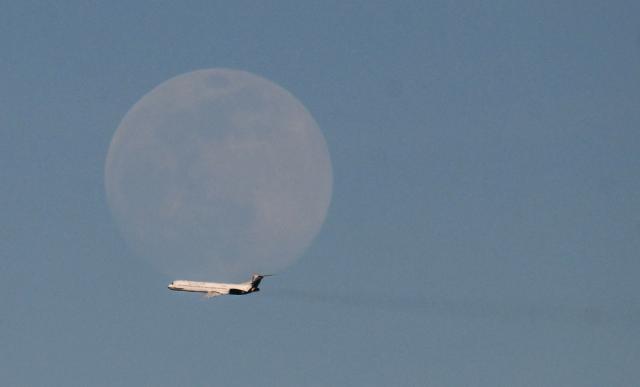 A Rutaca airlines plane flies in front of the moon as seen from Simon Bolivar International Airport in Maiquetia, Venezuela, on December 3, 2025. Venezuela announced on December 2, 2025, that it had reauthorized flights carrying migrants deported by the US, days after suspending them due to President Donald Trump's demand that Venezuelan airspace be considered "closed." (Photo by Juan BARRETO / AFP)