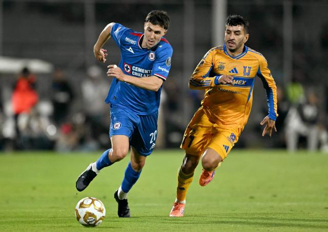 Cruz Azul's Argentine forward #20 Jose Paradela (L) and Tigres' Argentine forward #07 Angel Correa fight for the ball during the first leg of the Liga MX Apertura semifinal football match between Cruz Azul and Tigres at Banorte Stadium in Mexico City on December 3, 2025. (Photo by CARL DE SOUZA / AFP)