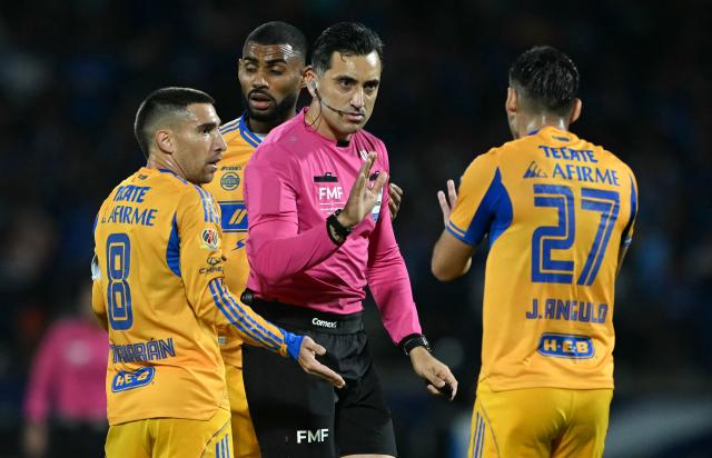 Referee Ismael Lopez talks to Tigres' defender #27 Jesus Angulo next to Uruguayan midfielder #08 Fernando Gorriaran during the first leg of the Liga MX Apertura semifinal football match between Cruz Azul and Tigres at Banorte Stadium in Mexico City on December 3, 2025. (Photo by CARL DE SOUZA / AFP)