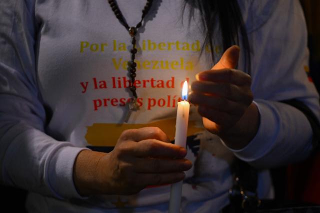 A Venezuelan citizen holds a candle during a vigil against Venezuela's President Nicolas Maduro and in support of US President Donald Trump at Lourdes Park in Bogota on December 3, 2025. Venezuela's President Nicolas Maduro confirmed on December 3, 2025, that he had a "cordial" phone call with his US counterpart Donald Trump 10 days ago amid a US military buildup in Latin America. (Photo by Luis ACOSTA / AFP)