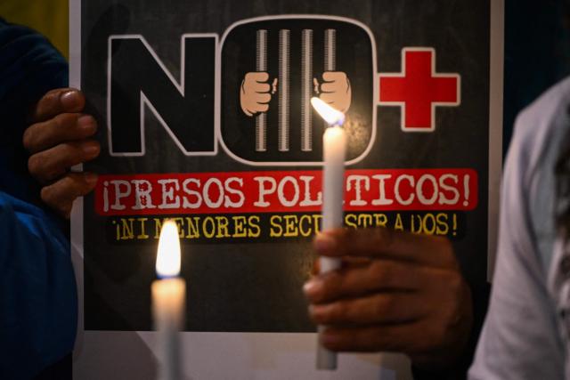 A Venezuelan citizen holds a candle during a vigil against Venezuela's President Nicolas Maduro and in support of US President Donald Trump at Lourdes Park in Bogota on December 3, 2025. Venezuela's President Nicolas Maduro confirmed on December 3, 2025, that he had a "cordial" phone call with his US counterpart Donald Trump 10 days ago amid a US military buildup in Latin America. (Photo by Luis ACOSTA / AFP)