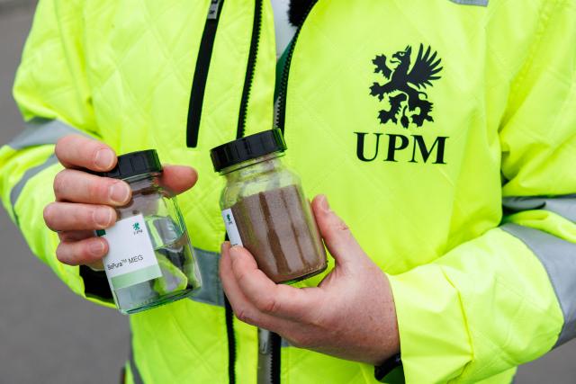 Harald Dialer, Executive Vice President Technology of UPM Biorefining & Technology stands with a jar with RRF (reniable functionelle fillers) and a jar with the end product monoethylene glycolin (MEG) in the front of the chemical plants of the UPM Biorefining & Technology in the Leuna Chemical Park near Leuna on November 14, 2025. Finnish materials group UPM unveiled a refinery in the east German state of Saxony-Anhalt in the summer, taking a big risk on a 1.3 billion euro project ($1.5 billion) at a difficult time for the German chemicals sector. (Photo by JENS SCHLUETER / AFP) / TO GO WITH AFP STORY