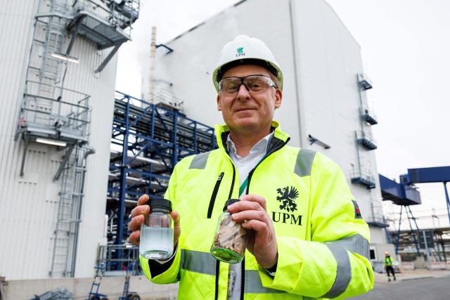 Harald Dialer, Executive Vice President Technology of UPM Biorefining & Technology stands with a jar with beech wood chips and a jar with the end product monoethylene glycolin in the front of the chemical plants of the UPM Biorefining & Technology in the Leuna Chemical Park near Leuna on November 14, 2025. Finnish materials group UPM unveiled a refinery in the east German state of Saxony-Anhalt in the summer, taking a big risk on a 1.3 billion euro project ($1.5 billion) at a difficult time for the German chemicals sector. (Photo by JENS SCHLUETER / AFP) / TO GO WITH AFP STORY