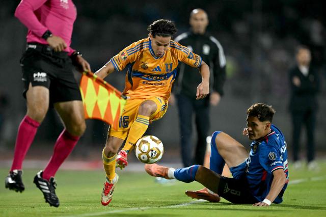 Tigres' midfielder #16 Diego Lainez (L) and Cruz Azul's defender #05 Jesus Orozco fight for the ball during the first leg of the Liga MX Apertura semifinal football match between Cruz Azul and Tigres at Banorte Stadium in Mexico City on December 3, 2025. (Photo by CARL DE SOUZA / AFP)