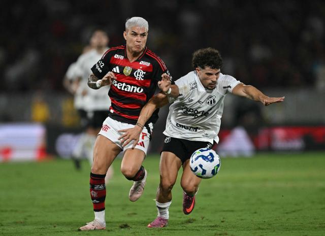 Flamengo's forward #07 Luiz Araujo (L) and Ceara's Portuguese defender #02 Rafael Ramos (R) fight for the ball during the Brasileirao Serie A football match between Flamengo and Ceara at Maracana Stadium in Rio de Janeiro, Brazil, on December 3, 2025. (Photo by Mauro PIMENTEL / AFP)