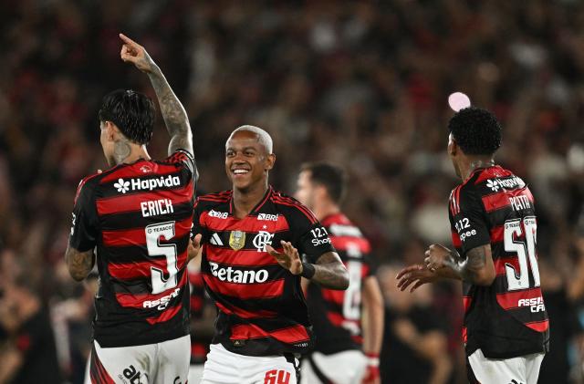 Flamengo's Chilean midfielder #05 Erick Pulgar, midfielder #64 Wallace and Ecuadorean midfielder #50 Gonzalo Plata celebrate the championship after winning the Brasileirao Serie A football match between Flamengo and Ceara at Maracana Stadium in Rio de Janeiro, Brazil, on December 3, 2025. (Photo by Mauro PIMENTEL / AFP)