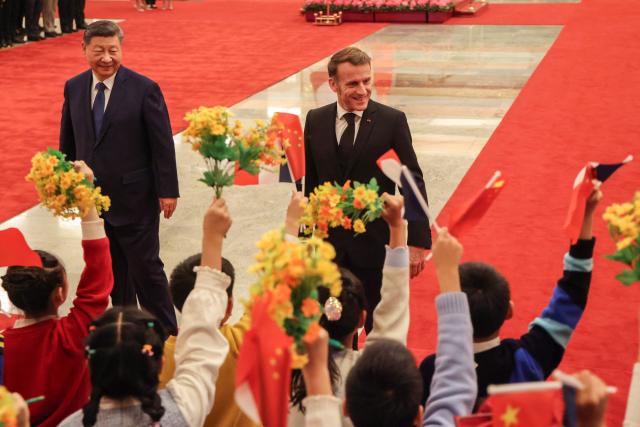 China's President Xi Jinping (L) and France's President Emmanuel Macron attend a welcome ceremony at the Great Hall of the People in Beijing on December 4, 2025. (Photo by Ludovic MARIN / POOL / AFP)