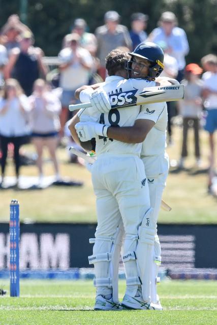 New Zealand's Tom Latham (L) is congratulated by his teammate Rachin Ravindra after scoring a century during day three of the first Test cricket match between New Zealand and West Indies at Hagley Oval in Christchurch on December 4, 2025. (Photo by Sanka Vidanagama / AFP)