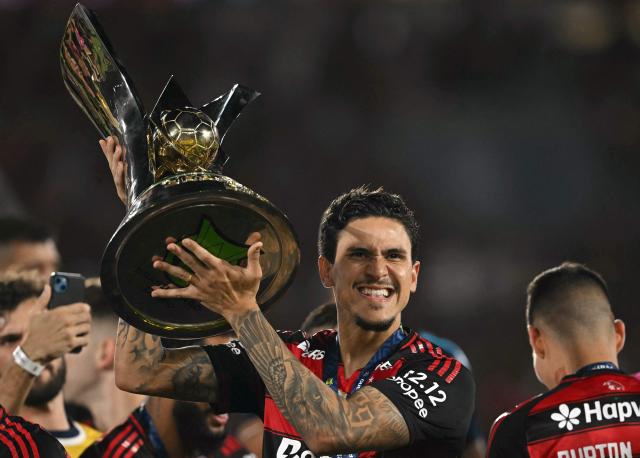 Flamengo's forward #09 Pedro lifts the Brasileirao trophy after winning the Brasileirao Serie A football match between Flamengo and Ceara at Maracana Stadium in Rio de Janeiro, Brazil, on December 3, 2025. (Photo by Mauro PIMENTEL / AFP)