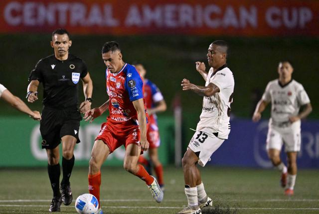 Xelaju's Paraguayan defender #04 Manuel Romero and Alajuelense's Colombian forward #33 Jeison Lucumi fight for the ball during the second leg of the CONCACAF Central American Cup final football match between Guatemala's Xelaju and Costa Rica's Alajuelense at Mario Camposeco Stadium in Quetzaltenango, Guatemala, on December 3, 2025. (Photo by JOHAN ORDONEZ / AFP)