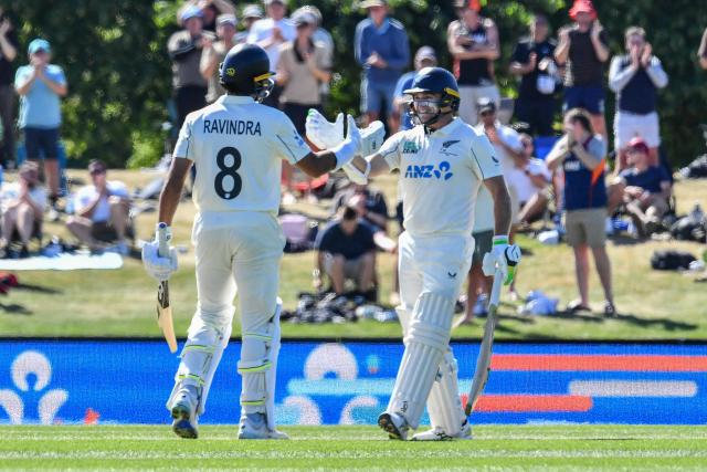 New Zealand's Rachin Ravindra (L) is congratulated by his teammate Tom Latham after scoring his century during day three of the first Test cricket match between New Zealand and West Indies at Hagley Oval in Christchurch on December 4, 2025. (Photo by Sanka Vidanagama / AFP)