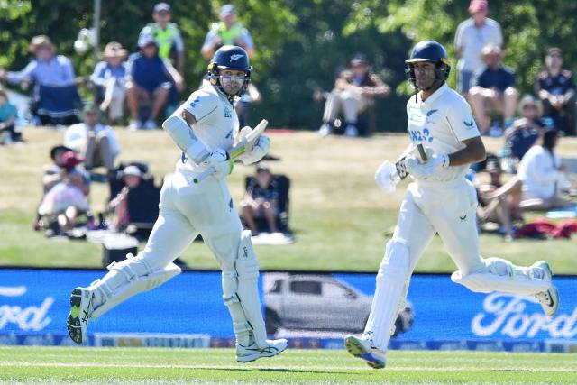 New Zealand's Rachin Ravindra (R) and Tom Latham run between the wickets during day three of the first Test cricket match between New Zealand and West Indies at Hagley Oval in Christchurch on December 4, 2025. (Photo by Sanka Vidanagama / AFP)