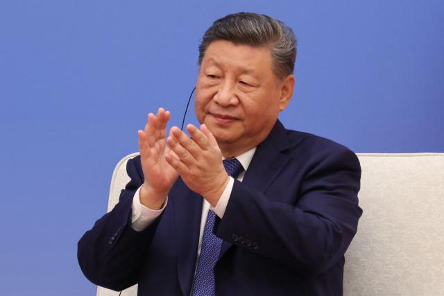 China's President Xi Jinping applauds during the 7th formal meeting of the Franco-Chinese Business Council in Beijing on December 4, 2025. (Photo by Ludovic MARIN / POOL / AFP)