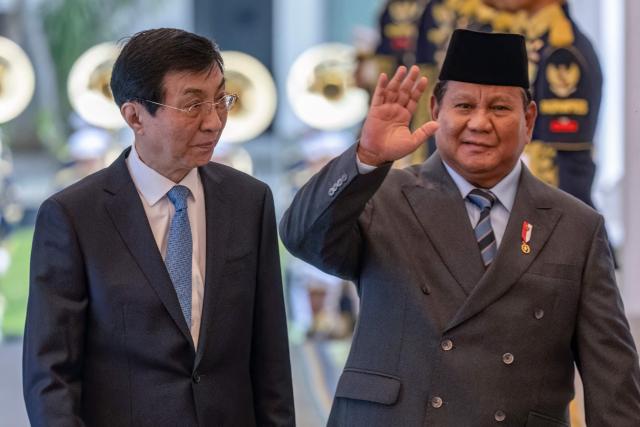 Indonesia's President Prabowo Subianto (R) welcomes Chairman of the Chinese People's Political Consultative Conference Wang Huning before their meeting at Merdeka Palace in Jakarta on December 4, 2025. (Photo by BAY ISMOYO / AFP)