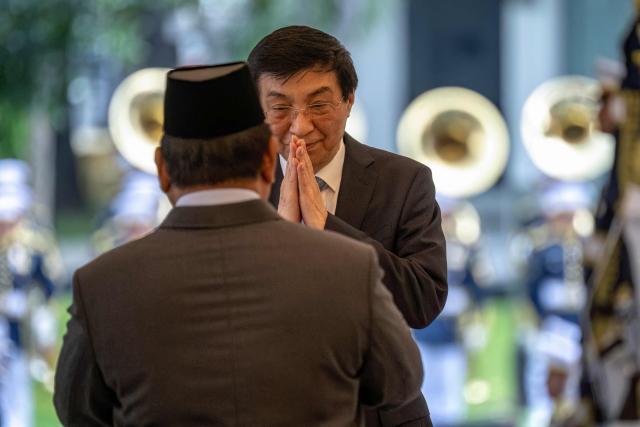 Indonesia's President Prabowo Subianto (L) welcomes Chairman of the Chinese People's Political Consultative Conference Wang Huning before their meeting at Merdeka Palace in Jakarta on December 4, 2025. (Photo by BAY ISMOYO / AFP)