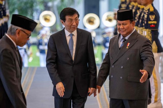 Indonesia's President Prabowo Subianto (R) welcomes Chairman of the Chinese People's Political Consultative Conference Wang Huning (C) before their meeting at Merdeka Palace in Jakarta on December 4, 2025. (Photo by BAY ISMOYO / AFP)