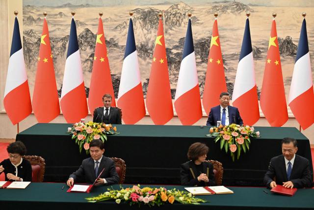 France’s President Emmanuel Macron (back, L) and China’s President Xi Jinping (back, R) attend a signing ceremony for agreements at the Great Hall of the People in Beijing on December 4, 2025. (Photo by Adek BERRY and ADEK BERRY / POOL / AFP)