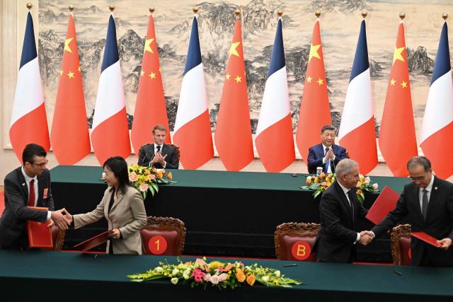 France’s President Emmanuel Macron (back, L) and China’s President Xi Jinping (back, R) applaud during a signing ceremony for agreements at the Great Hall of the People in Beijing on December 4, 2025. (Photo by Adek BERRY and ADEK BERRY / POOL / AFP)