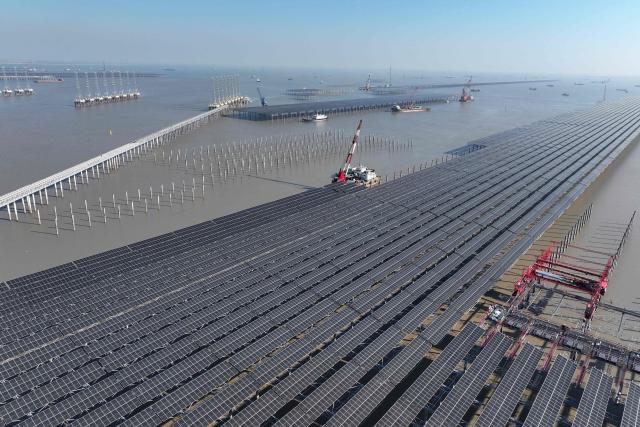 Aerial view of solar panels under construction at the 2 million kilowatt Zhonghe Tianwan photovoltaic project in a coastal tidal zone in Lianyungang, in China’s eastern Jiangsu province on December 4, 2025. (Photo by -STR / AFP) / China OUT