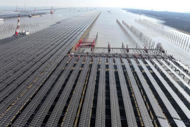 Aerial view of solar panels under construction at the 2 million kilowatt Zhonghe Tianwan photovoltaic project in a coastal tidal zone in Lianyungang, in China’s eastern Jiangsu province on December 4, 2025. (Photo by -STR / AFP) / China OUT