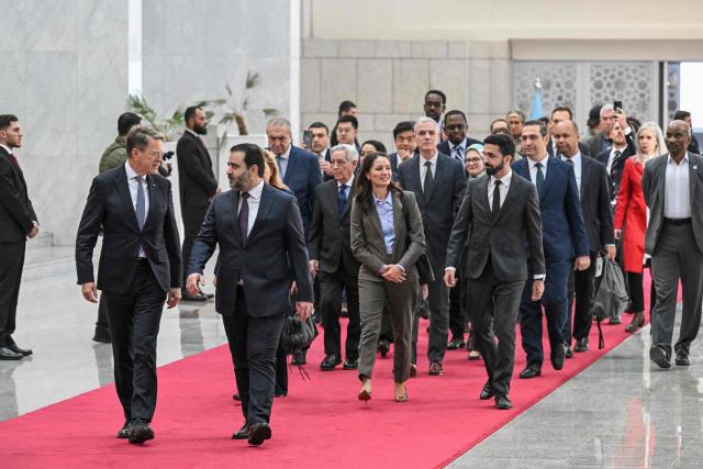 Syrian Minister of Foreign Affairs and Expatriates Asaad Al-Shaibani (front R) arrives to attend a reception with United Nations Security Council delegation at the Presidential Palace in Damascus on December 4, 2025. A United Nations Security Council delegation arrived in Syria on December 4, state media reported, the first-ever visit to the country just days before the anniversary of the ousting of longtime ruler Bashar al-Assad. The delegation arrived via the Jdeidet Yabus border crossing between Lebanon and Syria and "is scheduled to meet a number of Syrian officials" and members of civil society, state news agency SANA reported. (Photo by LOUAI BESHARA / AFP)