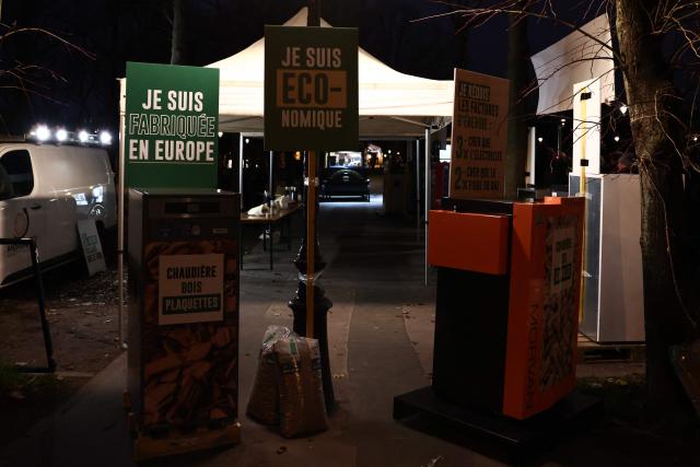 CORRECTION / This photograph shows signs reading "I am made in Europe" (top L) and "I am economical" (C) and two types of wood boilers during the demonstration of wood boilers to demand their reintegration into MaPrimeRenov's state aid, at the call of the French Biomass Boiler Manufacturers' Union (SFCB), in Paris, on December 4, 2025. (Photo by Thibaud MORITZ / AFP) / The erroneous mention[s] appearing in the metadata of this photo by Thibaud MORITZ has been modified in AFP systems in the following manner: [December 4] instead of [December 3]. Please immediately remove the erroneous mention from all your online services and delete it from your servers. If you have been authorized by AFP to distribute it to third parties, please ensure that the same actions are carried out by them. Failure to promptly comply with these instructions will entail liability on your part for any continued or post notification usage. Therefore we thank you very much for all your attention and prompt action. We are sorry for the inconvenience this notification may cause and remain at your disposal for any further information you may require.