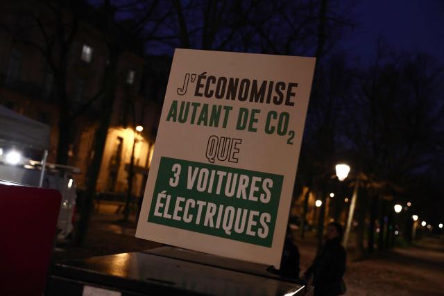 CORRECTION / This photograph shows a sign reading "I save as much CO2 as three electric cars" during the demonstration of wood boilers to demand their reintegration into MaPrimeRenov's state aid, at the call of the French Biomass Boiler Manufacturers' Union (SFCB), in Paris, on December 4, 2025. (Photo by Thibaud MORITZ / AFP) / “The erroneous mention[s] appearing in the metadata of this photo by Thibaud MORITZ has been modified in AFP systems in the following manner: [December 4] instead of [December 3]. Please immediately remove the erroneous mention from all your online services and delete it from your servers. If you have been authorized by AFP to distribute it to third parties, please ensure that the same actions are carried out by them. Failure to promptly comply with these instructions will entail liability on your part for any continued or post notification usage. Therefore we thank you very much for all your attention and prompt action. We are sorry for the inconvenience this notification may cause and remain at your disposal for any further information you may require.”
