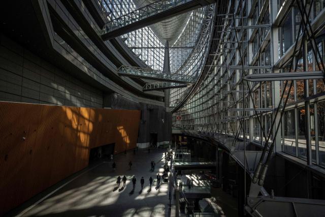 People walk through the Tokyo International Forum in Tokyo on December 4, 2025. (Photo by Yuichi YAMAZAKI / AFP)