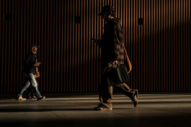 People walk through the Tokyo International Forum in Tokyo on December 4, 2025. (Photo by Yuichi YAMAZAKI / AFP)