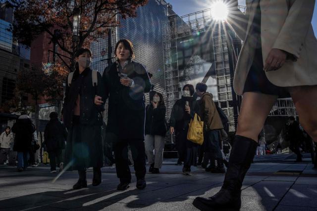 People walk through Ginza area in Tokyo on December 4, 2025. (Photo by Yuichi YAMAZAKI / AFP)