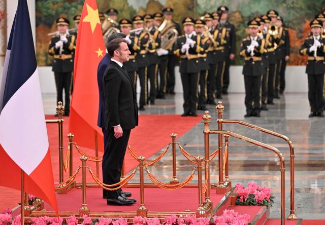 China’s President Xi Jinping (R) and France’s President Emmanuel Macron (L) stand during a welcome ceremony at the Great Hall of the People in Beijing on December 4, 2025. (Photo by Adek BERRY and ADEK BERRY / POOL / AFP)