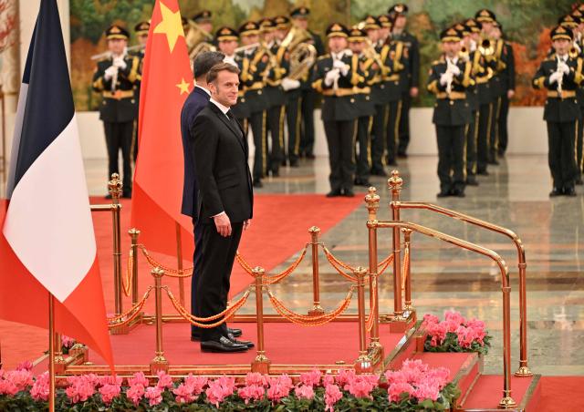 China’s President Xi Jinping (R) and France’s President Emmanuel Macron (L) stand during a welcome ceremony at the Great Hall of the People in Beijing on December 4, 2025. (Photo by Adek BERRY and ADEK BERRY / POOL / AFP)